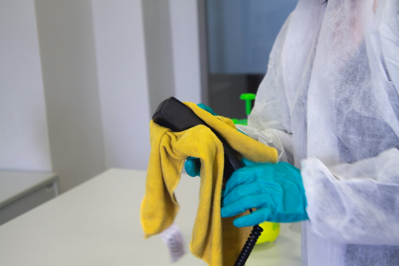 Cleaner in protective gear performing an industrial-grade facility deep clean